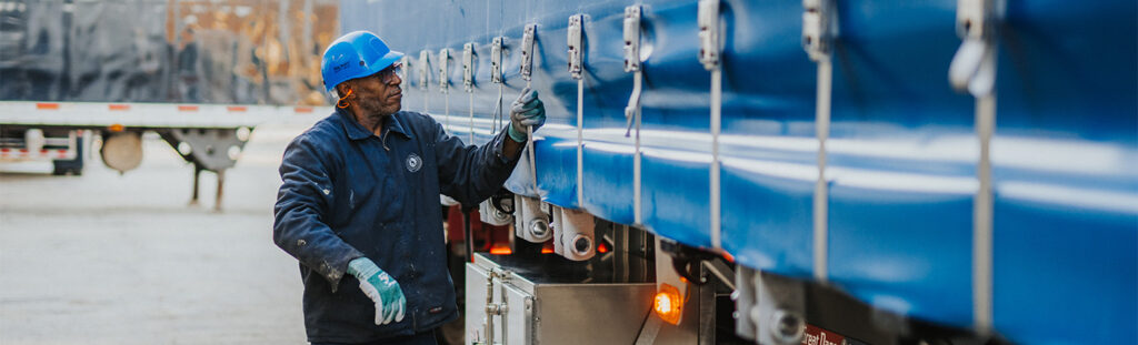 Truck driver walking alongside his trailer
