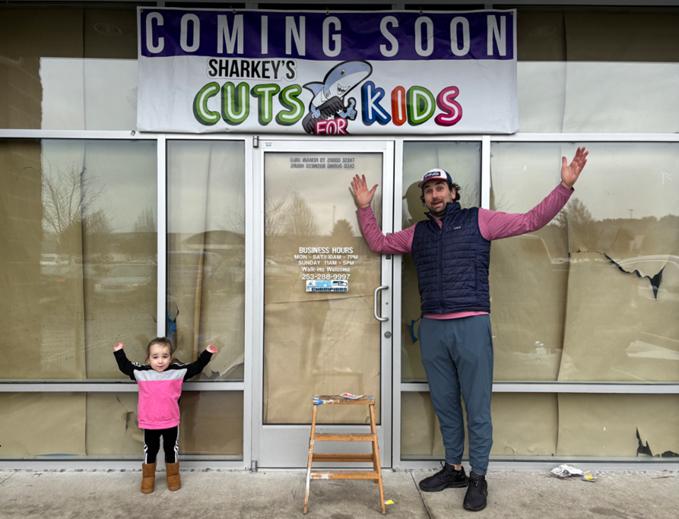 Father and daughter standing in front of a Sharkey's Cuts location in Auburn, WA